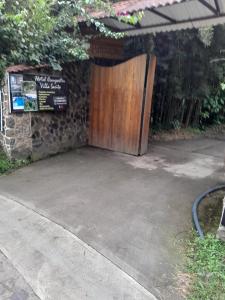 圣弗朗西斯科Hotel campestre Villa Sarita的车道上的木门,有标志