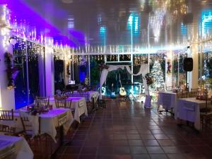 圣弗朗西斯科Hotel campestre Villa Sarita的宴会厅配有白色桌子和圣诞装饰