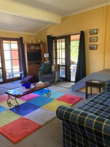 库马库马伍德维尔度假屋的客厅配有沙发和色彩缤纷的地毯