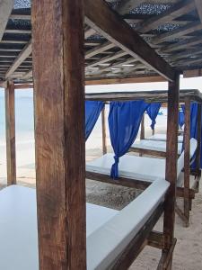 巴尔Cabañas Palos Locos的海滩上的一张带蓝色窗帘的床