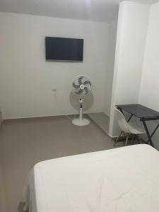 巴耶杜帕尔Ibiza2的一间卧室配有一张床、一台电视和一把椅子