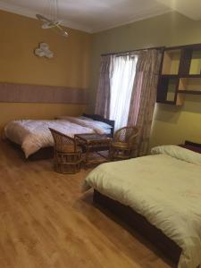 加德满都Bodhi Homestay的一间卧室设有两张床、椅子和窗户
