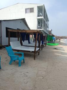巴尔Cabañas Palos Locos的海滩上一张床铺和一张蓝色椅子