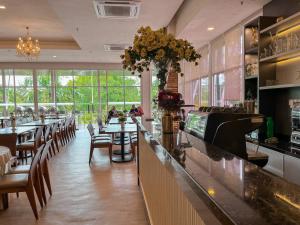 瓜拉丁加奴苏麦公寓酒店的餐厅设有酒吧,配有桌椅