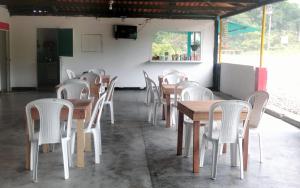 比利亚加松Encanto Natural的配有木桌和白色椅子的餐厅