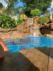Capim BrancoHotel Fazenda Tucano的一个带瀑布的游泳池和一个游泳池