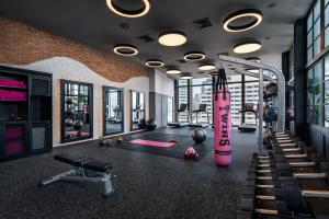曼谷曼谷拉差阿帕森购物区 MOXY 酒店的一个带粉色跑步机和健身器材的健身房