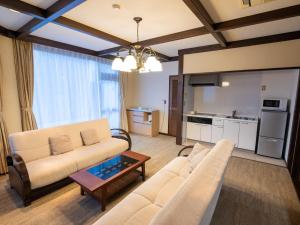 伊东内萨城崎旅馆的客厅配有沙发和桌子