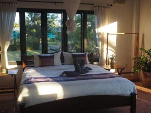清迈Countryside getaway home (inc breakfast)的一间卧室设有一张大床和大窗户