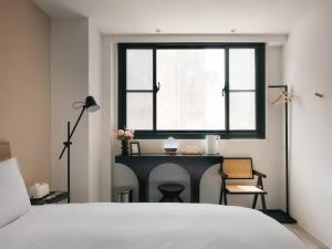 台南廣發寓所的一间卧室配有书桌、窗户和床。