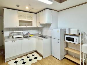 首尔ChaenHaus的厨房配有白色橱柜和冰箱。