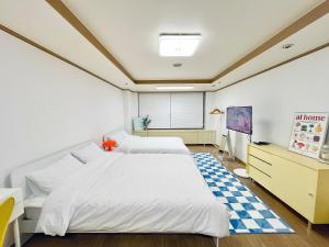 首尔ChaenHaus的一间卧室设有两张床,铺有一个 ⁇ 板地板