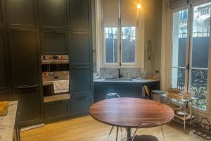 巴黎Atypical house with garden的厨房配有木桌和水槽。