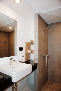 清迈Peppery Hills的浴室配有盥洗盆和带镜子的淋浴