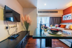 八打灵再也Resort Suite 6pax Homestay at Sunway Pyramid&Sunway Lagoon的客厅配有沙发和墙上的电视