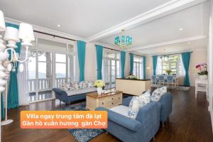 阿普春安Villa Hạng Sang Đà Lạt - Gần Hồ Xuân Hương Gần Chợ Đà Lạt的客厅配有蓝色的家具和蓝色的窗帘