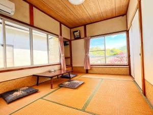 下田Iriyama-So的一间设有桌子和两个窗户的房间