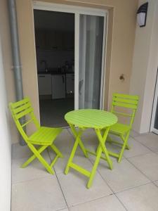 莱斯安格尔斯Cozy studio near Avignon的庭院设有两把椅子和一张绿色的桌子及椅子