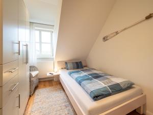 斯匹科罗格Dünenkieker的小型阁楼卧室设有1张床和1扇窗户。