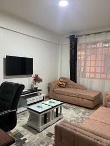 纳库鲁Silva-Mindvalley的带沙发和平面电视的客厅
