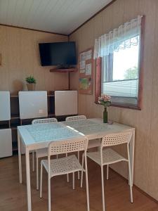 乌斯特卡Domki WIKA 2的一间带桌椅和电视的用餐室