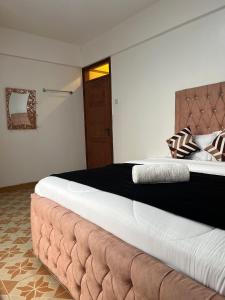纳库鲁Silva-Mindvalley的一间卧室配有一张大床和棕色床头板