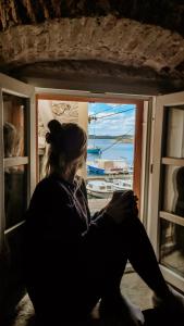 希贝尼克City Rooms Šibenik的坐在窗外望水的女人