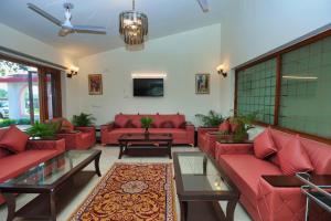 BahoraDe Vivendi Farm- A Rural Luxury Farmhouse Getaway的客厅配有红色沙发和电视
