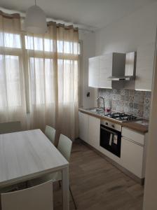 巴勒莫Casa Giannina的厨房配有白色橱柜和桌椅