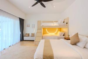 Kampong Si GintingSuntai Villa, Beachfront Suites的一间卧室配有两张床和吊扇