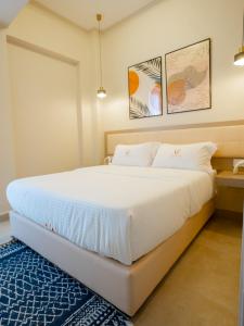 内罗毕Zarafa Suites的卧室配有一张白色大床和蓝色地毯