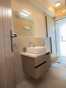 内罗毕Zarafa Suites的一间带水槽、卫生间和镜子的浴室