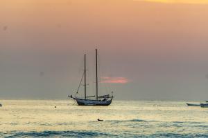 塔马林多Casa Nella的日落时分在海洋中的帆船