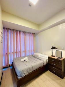 Lapu Lapu City8 Newtown Boulevard by Hiverooms的一间卧室配有一张带灯和窗户的床