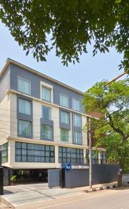 新德里Best Western Maharani Bagh New Delhi的一条树上街道上的公寓楼