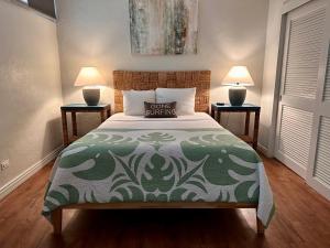 帕依亚North Shore of Maui - 2bd-2bath的一间卧室配有一张带绿色被子的床和两盏灯。