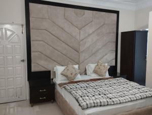 卡拉奇Hotel Shelton的一间卧室配有一张大床和大床头板