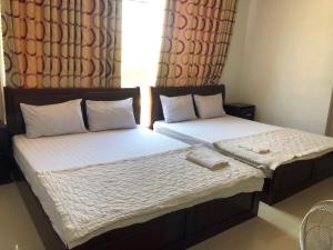 潘郎Nam Dương 2 Hotel的卧室设有两张单人床和窗户。