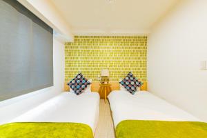 大阪JA Hotel Midoribashi 綠橋的配有2张单人床的带墙壁客房