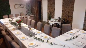 埃尔布隆格Galeona - Hotel turystyczny的一张长桌子,上面有白色的板子和花