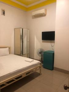 潘郎Nam Dương 3 Hotel的客房设有1张带冰箱和电视的床。