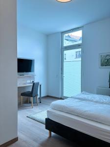 唐格明德Pension Töpferhof的蓝色的客房配有一张床和一张书桌及一台电视