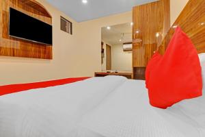 孟买OYO Hotel Royal Park的卧室配有带红色枕头的大型白色床