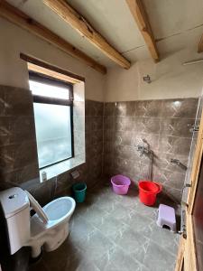 斯潘格米克Mystic Pangong的带浴缸、卫生间和水桶的浴室