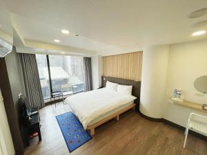 宜兰市可青大飯店Grand Ke-Cing Hotel的一间卧室设有一张床和一个大窗户
