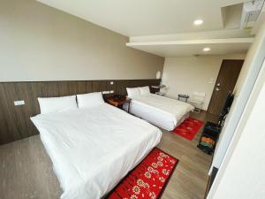 宜兰市可青大飯店Grand Ke-Cing Hotel的酒店客房带两张床和红色地毯