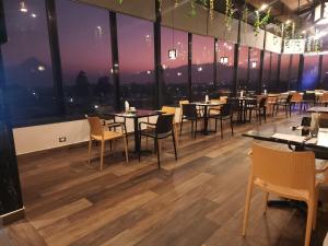克萨尔特南戈Hotel Luna de Plata Aeropuerto的餐厅设有桌椅和大窗户。