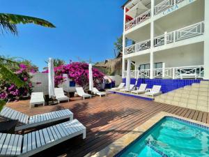 托弗海滩Casa Do Mar Guest House的一个带游泳池和椅子的度假胜地和一座建筑