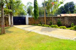 基苏木Yuks Villa的一个带石墙和围栏的院子