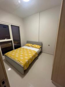 ‘Ūd al BayḑāʼApartmán Fiora, 2kk,Dubaj的一间卧室配有一张带黄色床单的床和一扇窗户。